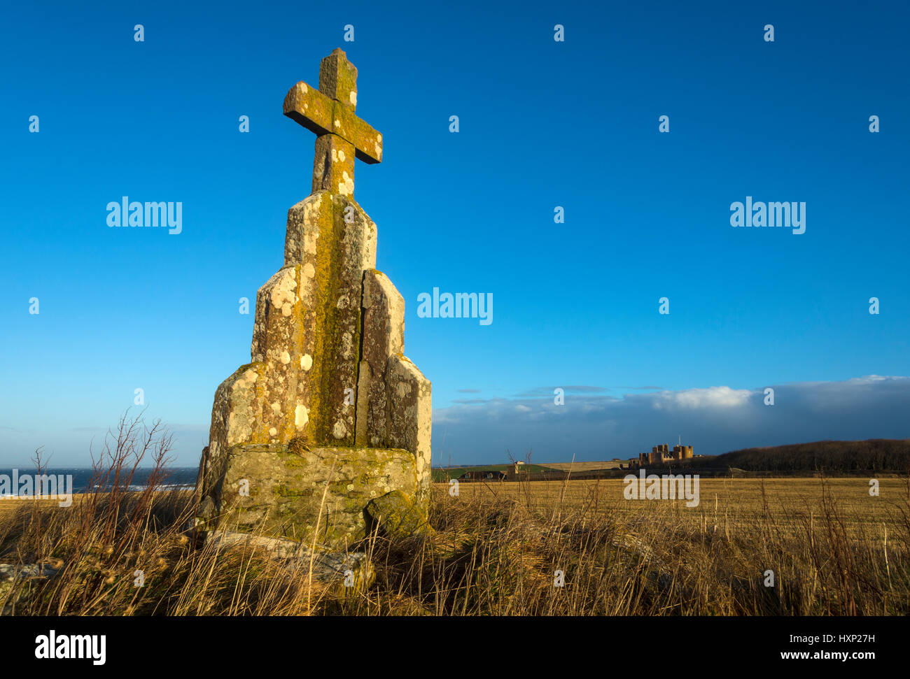 Stone cross on the Cairn of Mey, near the village of Mey, Caithness, Scotland, UK. Castle of Mey in the distance. Stock Photo