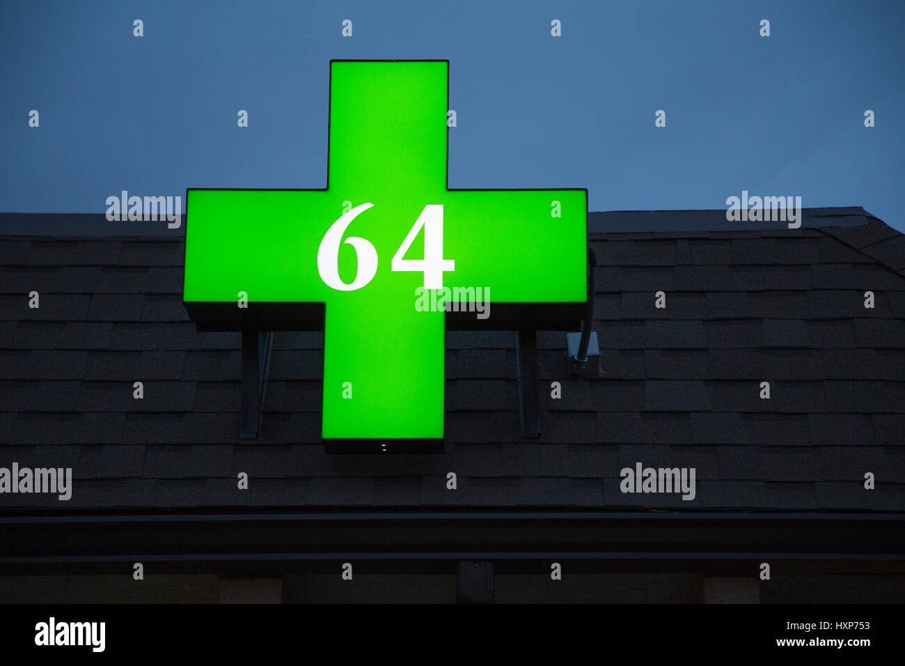 A green cannabis dispensary pharmacy sign with the number '64' representing the Colorado Marijuana Legalization Amendment, also known as Amendment 64 Stock Photo