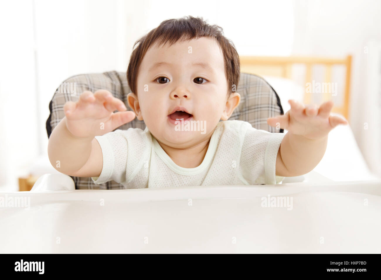 Baby sitting in high chair Stock Photo Alamy