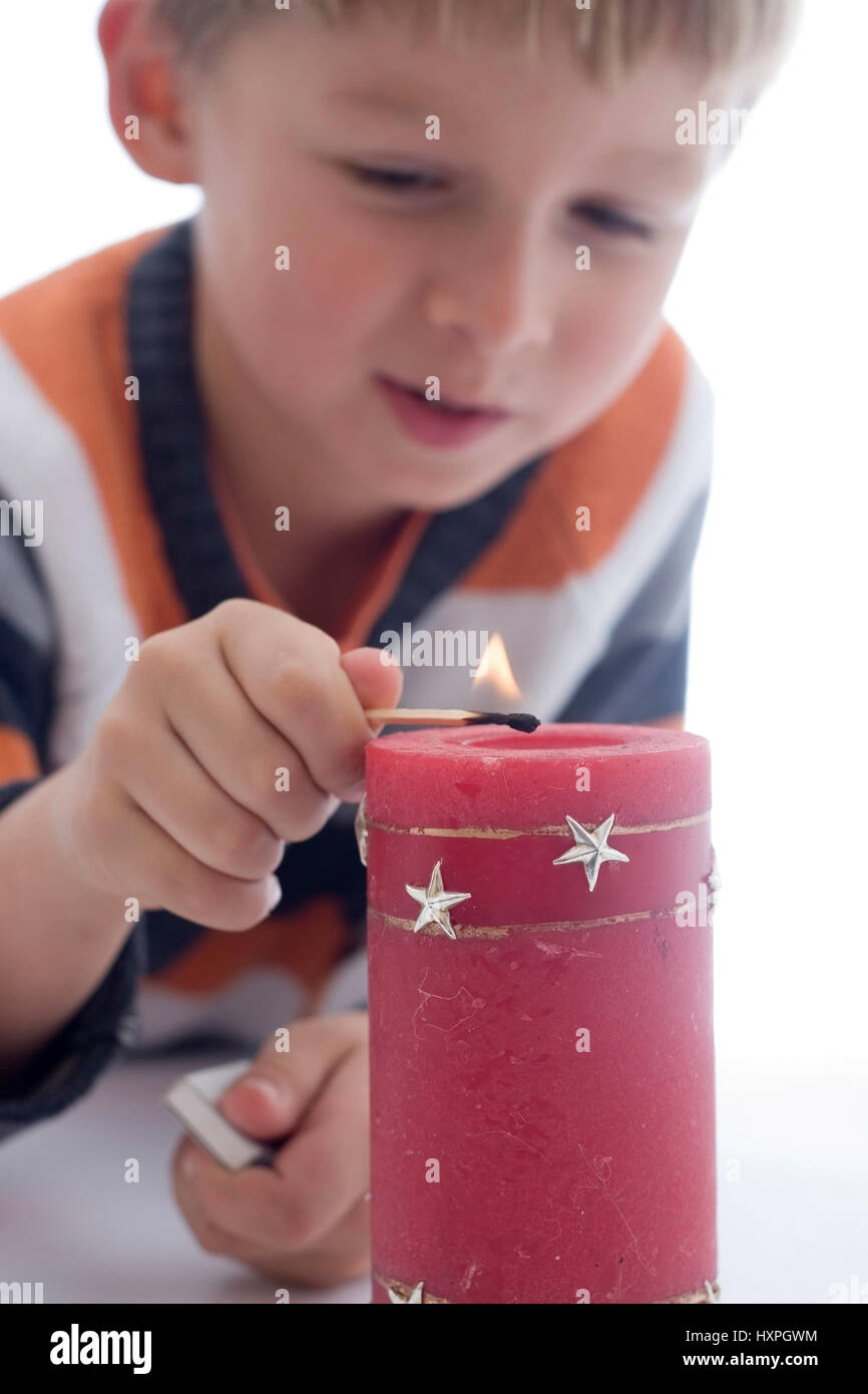 6-year-old boy lights candle (released), sechsjähriger Junge zündet Kerze an (modell released) Stock Photo