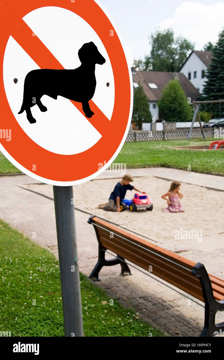 Dog no parking sign stands before a children's playground (no Pr), Hundeverbotsschild steht vor einem Kinderspielplatz (no pr) Stock Photo