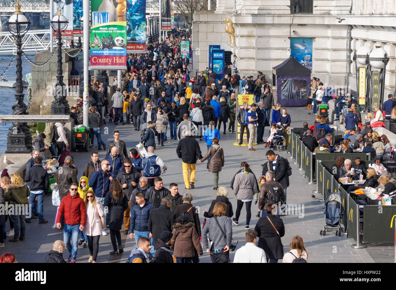 People at the Queen's Walk promenade on the southern bank of the River Thames, London England United Kingdom UK Stock Photo