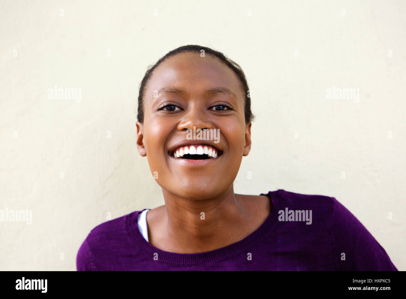 Close up portrait of smiling young african woman against white ...