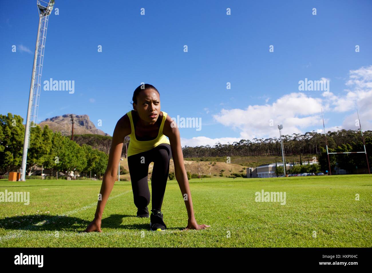 Portrait of young female athlete in starting position Stock Photo