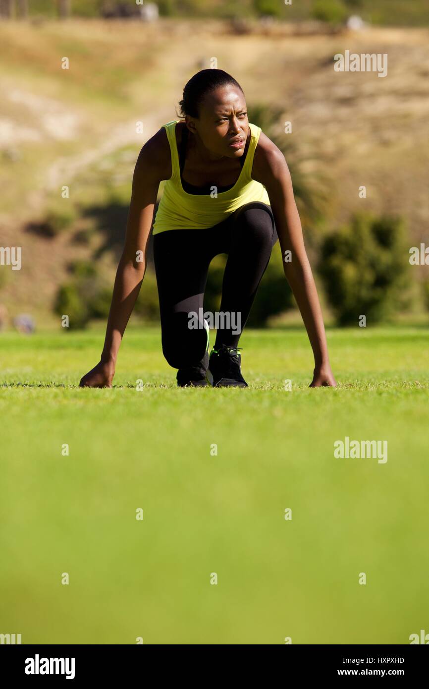 Portrait of young african female athlete at starting position ready to start a race Stock Photo