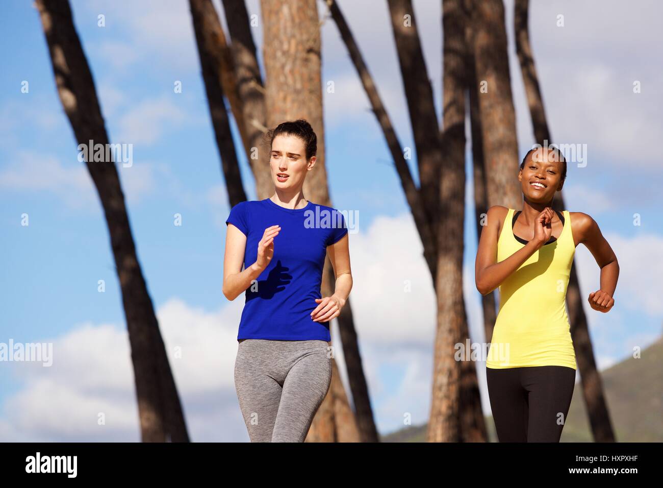 Portrait of fit young women running outdoors in nature Stock Photo - Alamy