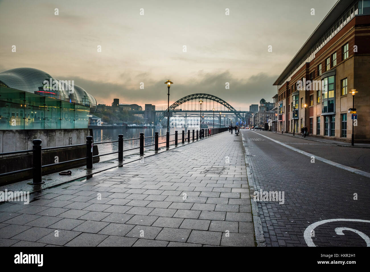 Looking westwards at sunset along the quays of the River Tyne towards Tyne Bridge, Newcastle upon Tyne, Tyne and Wear, England Stock Photo