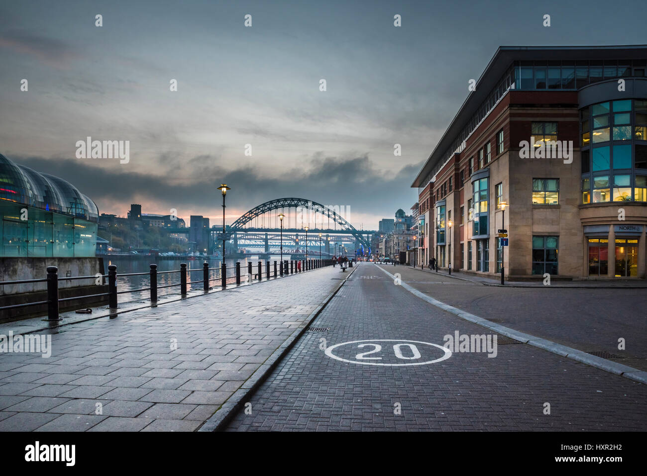 Looking westwards at sunset along the quays of the River Tyne towards Tyne Bridge, Newcastle upon Tyne, Tyne and Wear, England Stock Photo