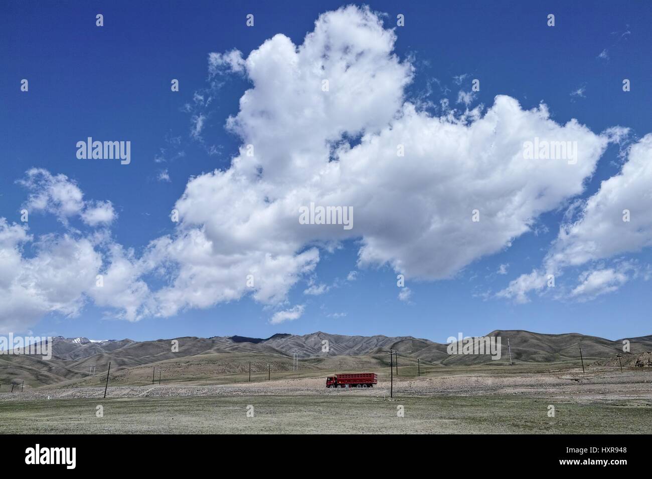 The galloping truck on the road in Bayinbulak grassland, Xinjiang of China Stock Photo