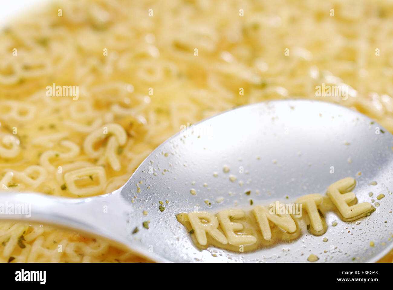 The word Pension with noodle letter on a spoon, Das Wort Rente mit Nudelbuchstaben auf einem Löffel Stock Photo