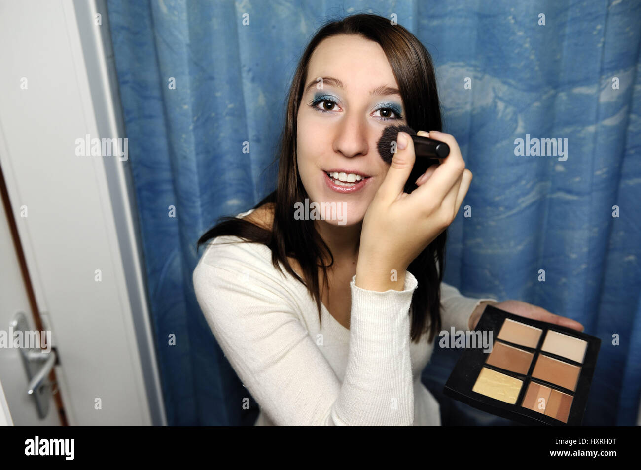 Young woman makes herself up before the mirror, Junge Frau schminkt ...