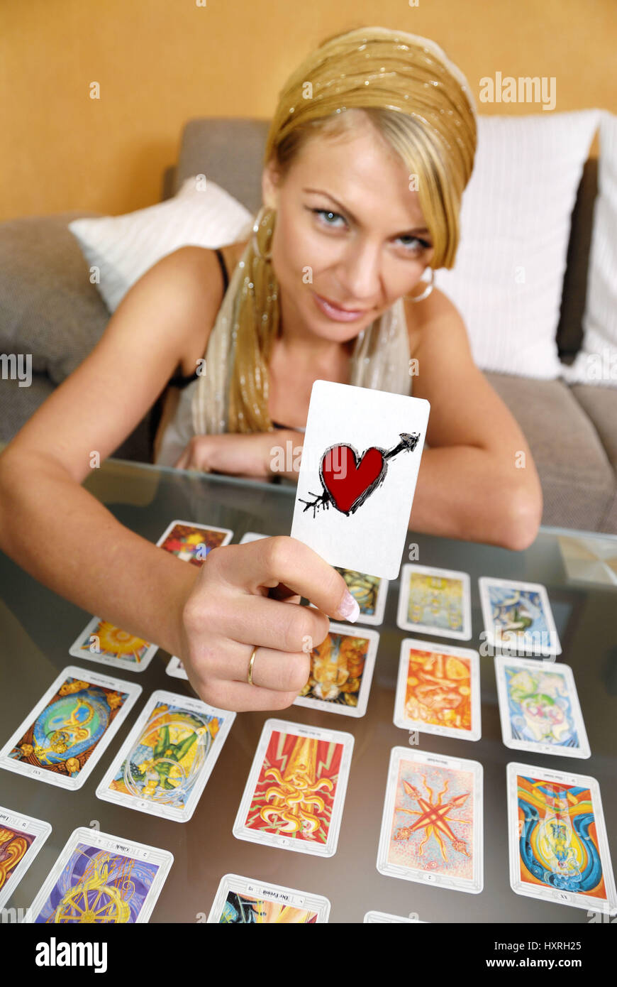 Woman shows tarot map with heart, Frau zeigt Tarotkarte mit Herz Stock Photo
