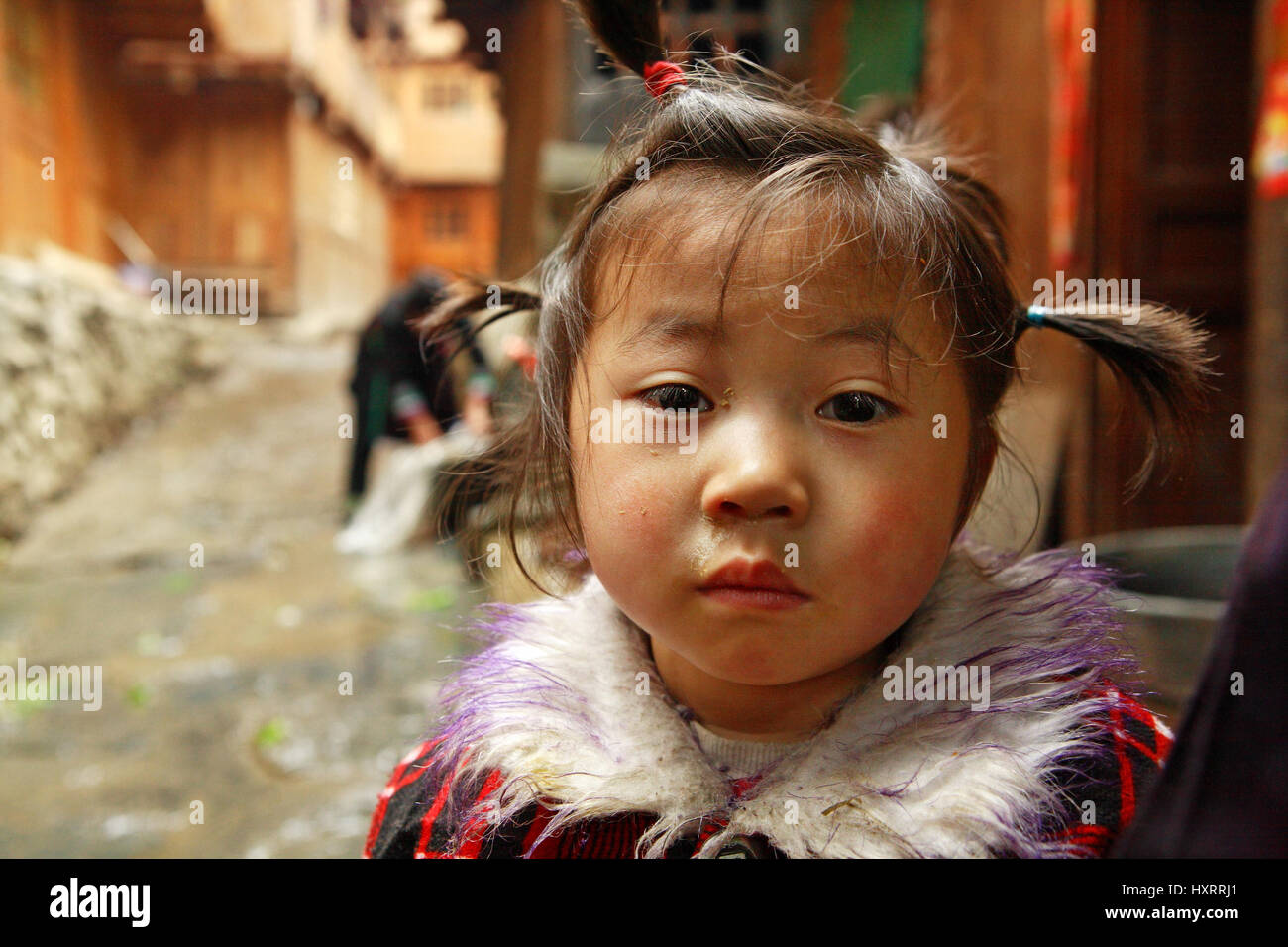 GUIZHOU PROVINCE, CHINA - APRIL 13: Rural girl 4 years old, standing on a village street in south-west China, April 13, 2010. Asian child in the rural Stock Photo
