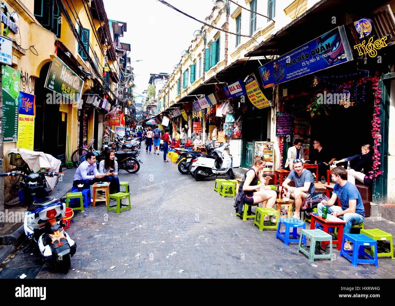 Tourists enjoy refreshments in Hanoi side street Stock Photo