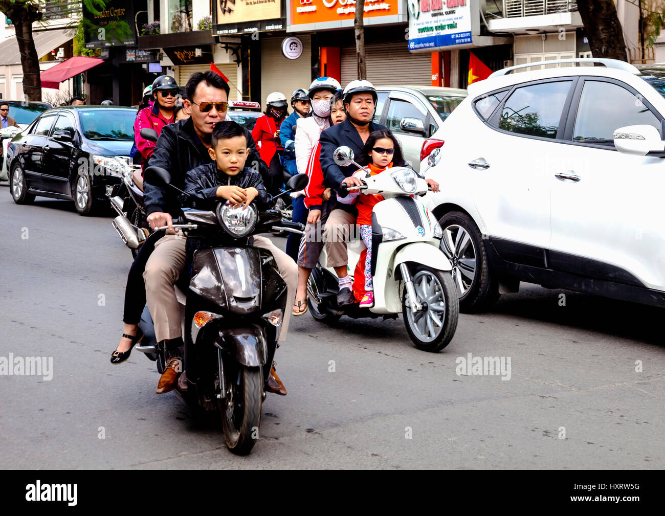 Vietnamese families heading to Lunar New Year celebrations in Hanoi by motor bike Stock Photo
