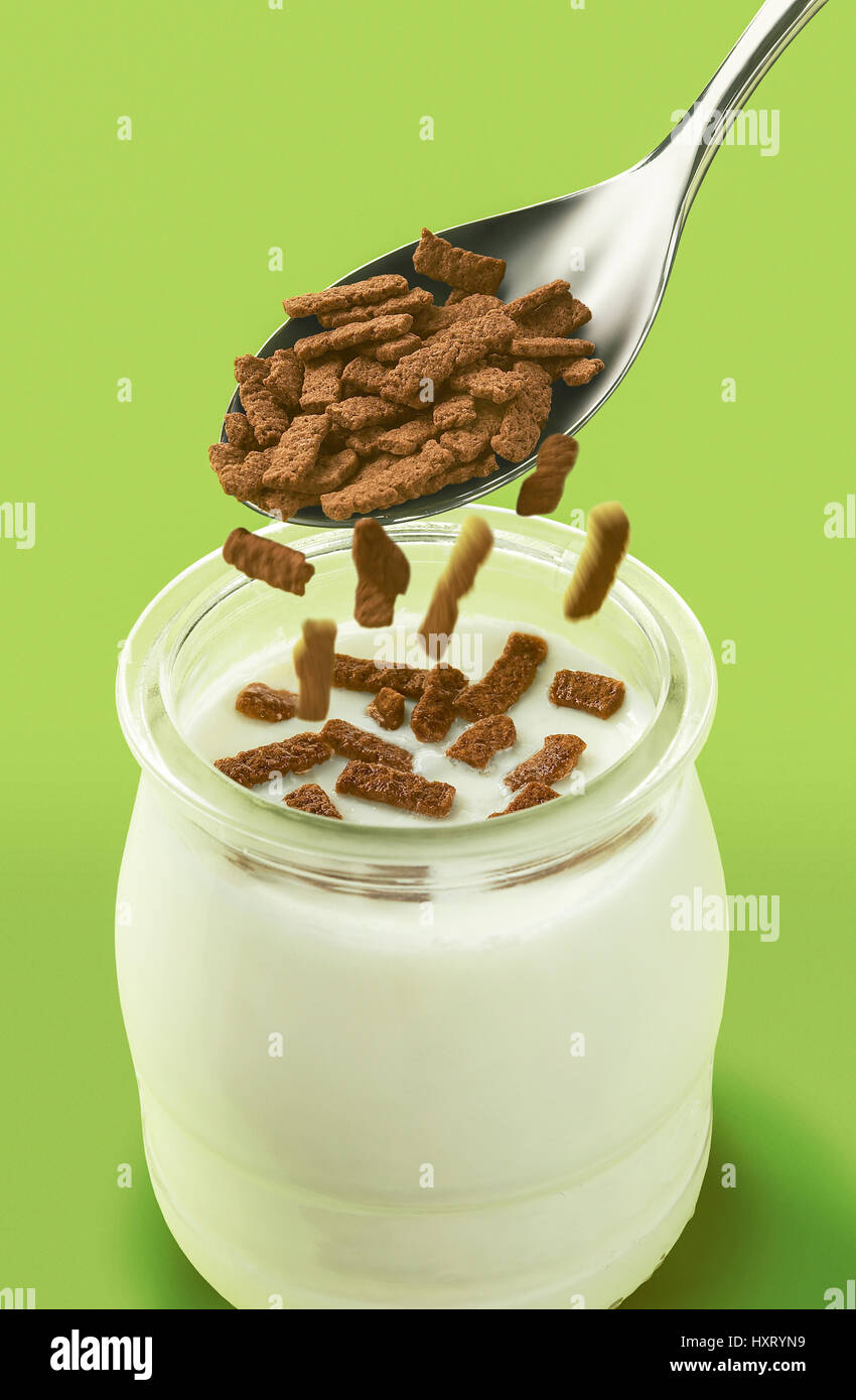recipiente de yoghourt natural con cuchara y cereales Stock Photo