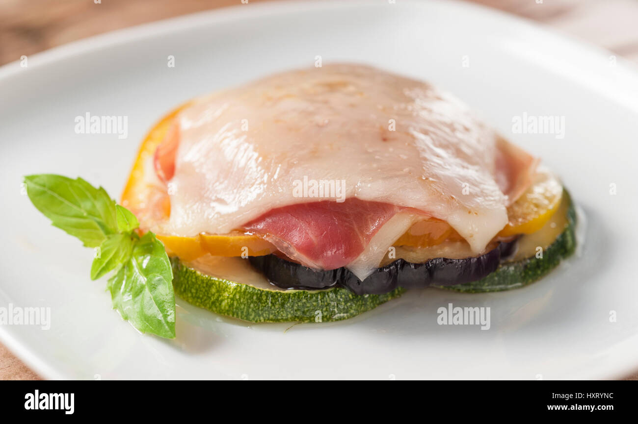 zucchini and eggplant lasagna filled with ham au gratin on a square