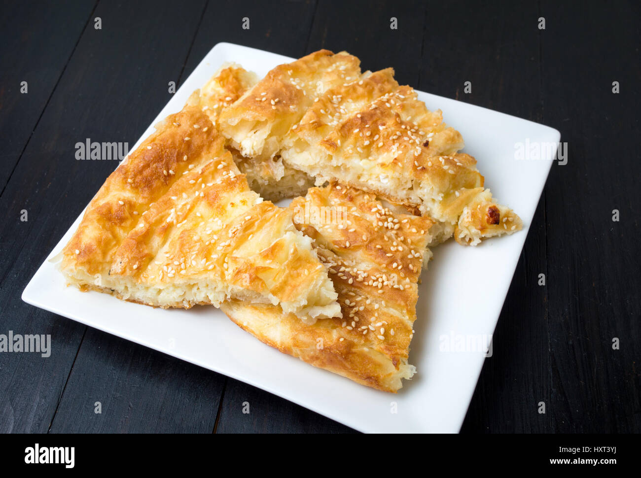 Cheese pie covered with sesame on a plate Stock Photo