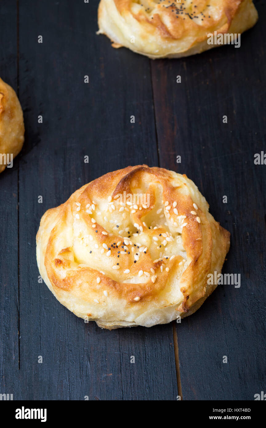 Homemade cheese pie rolls covered with sesame on a table Stock Photo