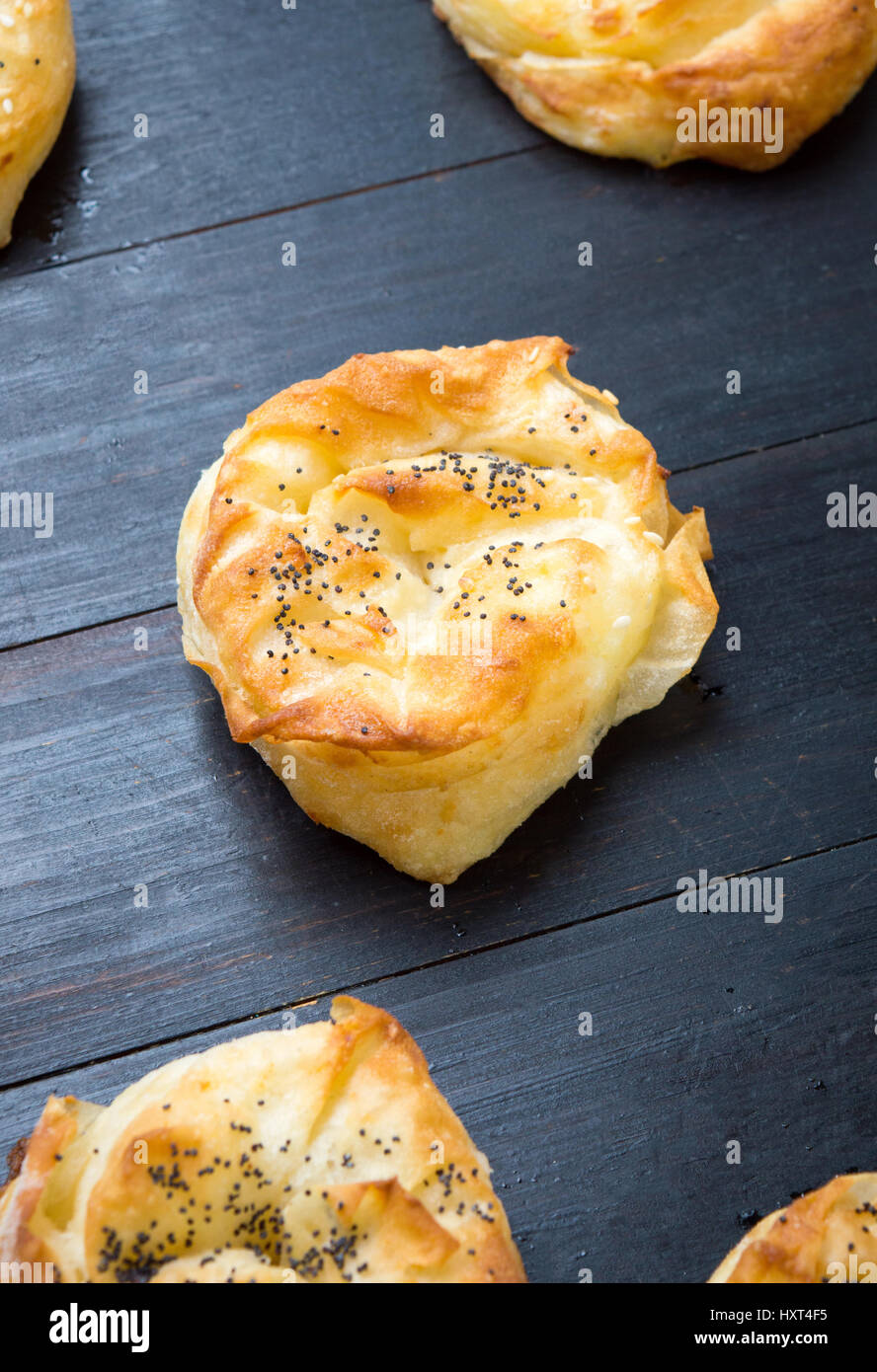 Homemade cheese pie rolls covered with sesame on a table Stock Photo