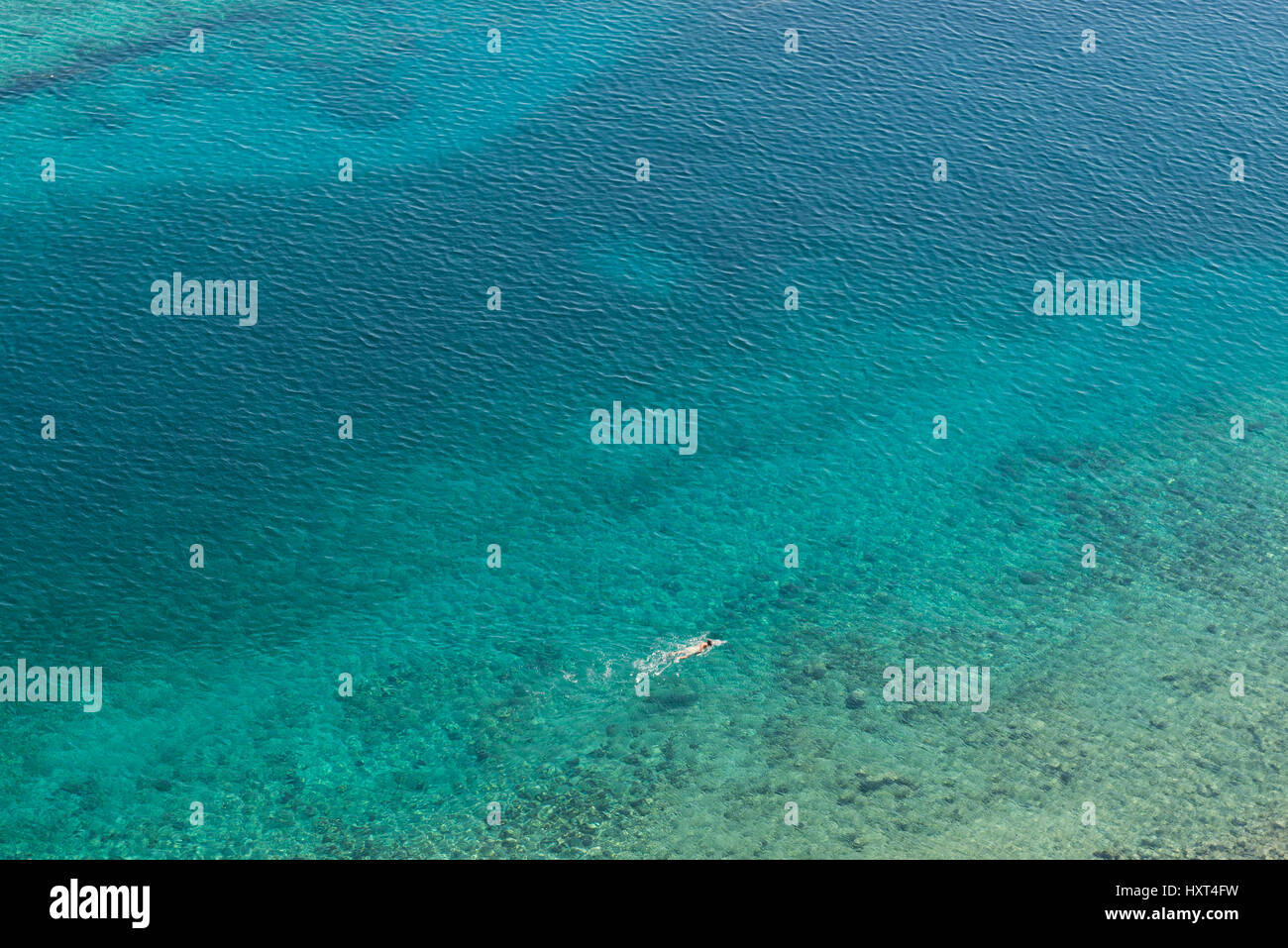 erhöhte Ansicht auf einsamen Schwimmer in azurblauem Wasser, Insel Kastellorizo,Dodekanes, Griechenland Stock Photo