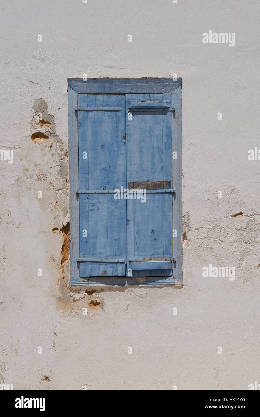 hellblaue geschlossene Fensterläden in weißer bröckelnder Hauswand, Insel Kastellorizo, Dodekanes, Griechenland Stock Photo