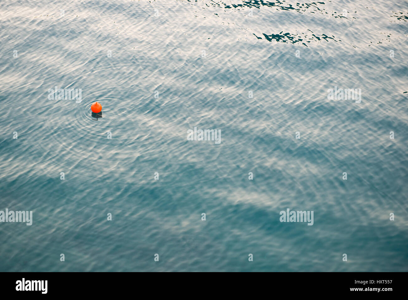 leicht bewegtes Wasser dunkelgrün mit rotes Boje in Mitte links und Spiegelung, Insel Kastellorizo, Dodekanes, Griechenland Stock Photo
