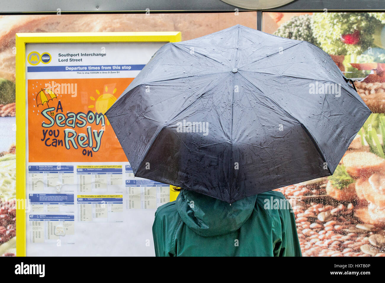 Southport, Merseyside. 30th March 2017. UK Weather. Heavy rains pour down over the north west seaside resort of Southport in Merseyside. Shoppers & commuters alike take whatever steps necessary to cover up from the torrential downpours. Credit: Cernan Elias/Alamy Live News Stock Photo