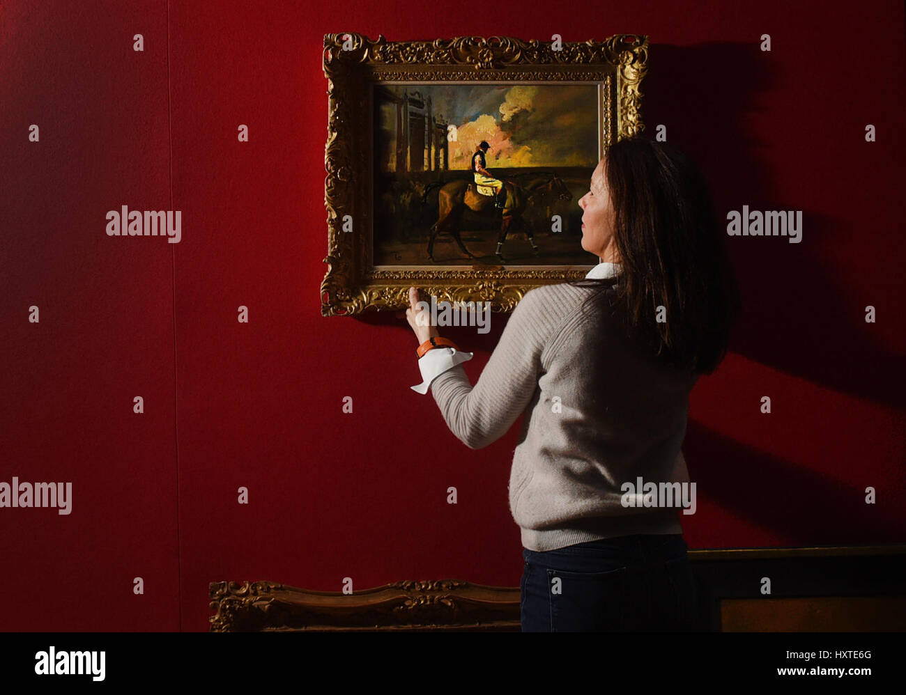 Oxford, UK. 29th Mar, 2017. Antique dealers setting up for The Cotswolds Art and Antiques Dealers' Association (CADA) Fair, which runs over the weekend, 30th March - 2nd April at Blenheim Palace, Woodstock, Oxfordshire, UK. Beth Marsden of Trinity House Paintings hangs 'After The Race Newbury' by Sir Alfred Mannings. Picture by Richard Cave 29.03.17 Credit: Richard Cave/Alamy Live News Stock Photo