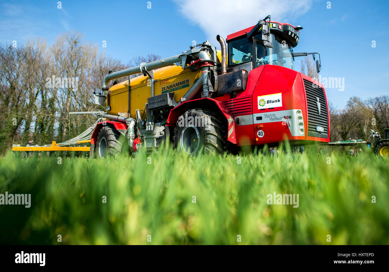A tractor fitted with a drip hose boom spreads organic fertiliser on a field near Salzgitter in the state of Lower Saxony, Germany, 30 March 2017. The Chamber of Agriculture in the state has invited farmers to a demonstration to learn current techniques for the spreading of fertilisers in the correct amounts. Photo: Hauke-Christian Dittrich/dpa Stock Photo
