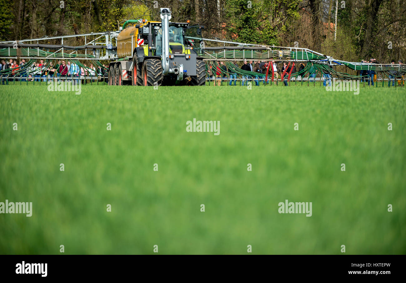 A tractor fitted with a drip hose boom spreads organic fertiliser on a field near Salzgitter in the state of Lower Saxony, Germany, 30 March 2017. The Chamber of Agriculture in the state has invited farmers to a demonstration to learn current techniques for the spreading of fertilisers in the correct amounts. Photo: Hauke-Christian Dittrich/dpa Stock Photo