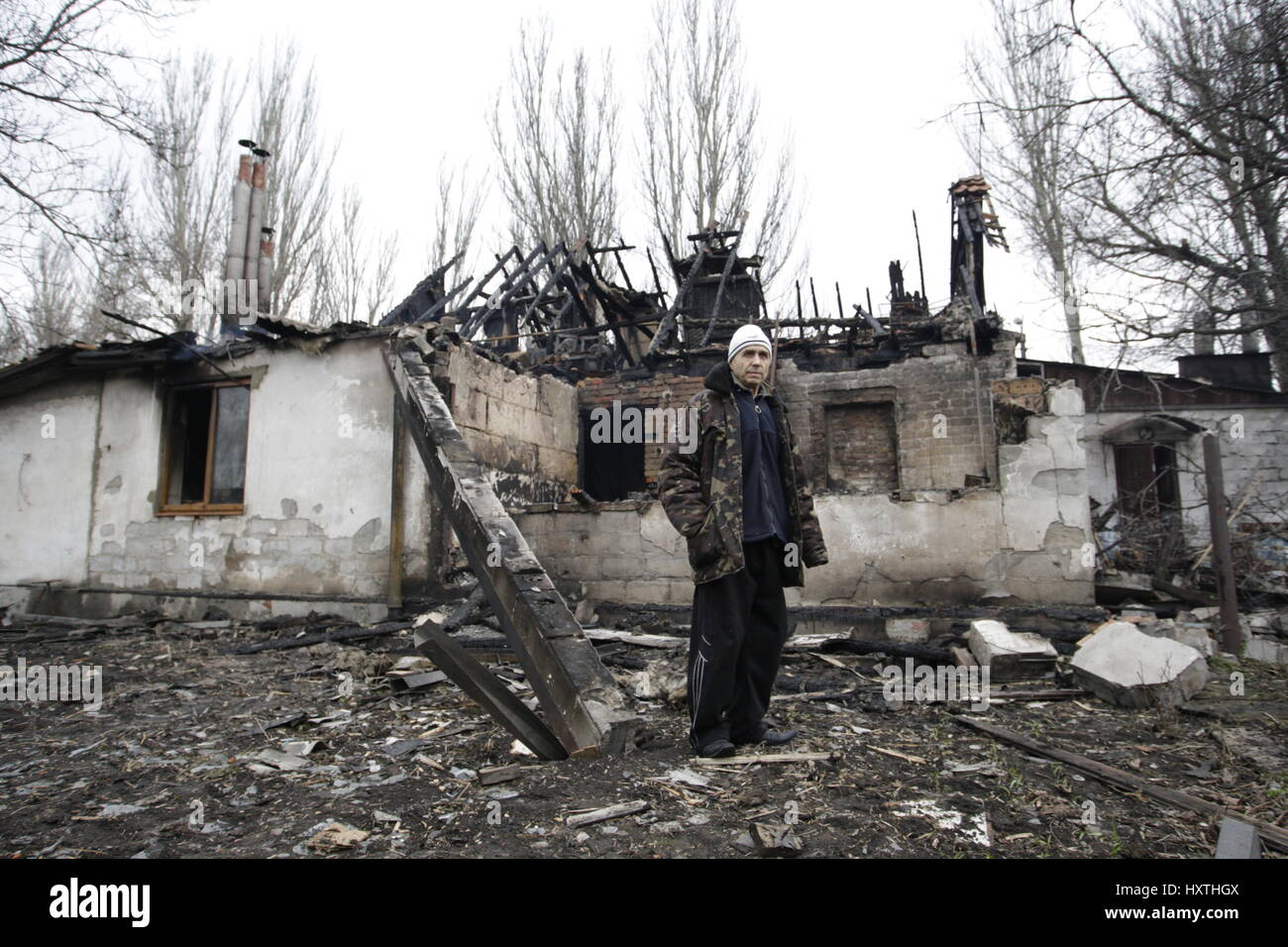 Donetsk, Ukraine. 30th Mar, 2017. A man stands in front of a damaged house in Donetsk, eastern Ukraine, on March 30, 2017. Several living buildings were damaged after heavy shelling in Donetsk. Credit: Alexander Ermochenko/Xinhua/Alamy Live News Stock Photo
