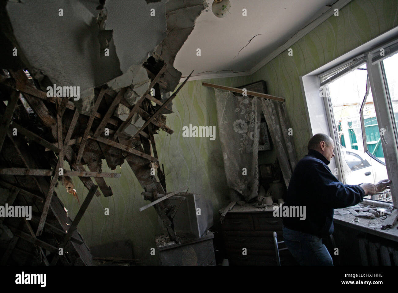 Donetsk, Ukraine. 30th Mar, 2017. A man inspects the damage of his house in Donetsk, eastern Ukraine, on March 30, 2017. Several living buildings were damaged after heavy shelling in Donetsk. Credit: Alexander Ermochenko/Xinhua/Alamy Live News Stock Photo