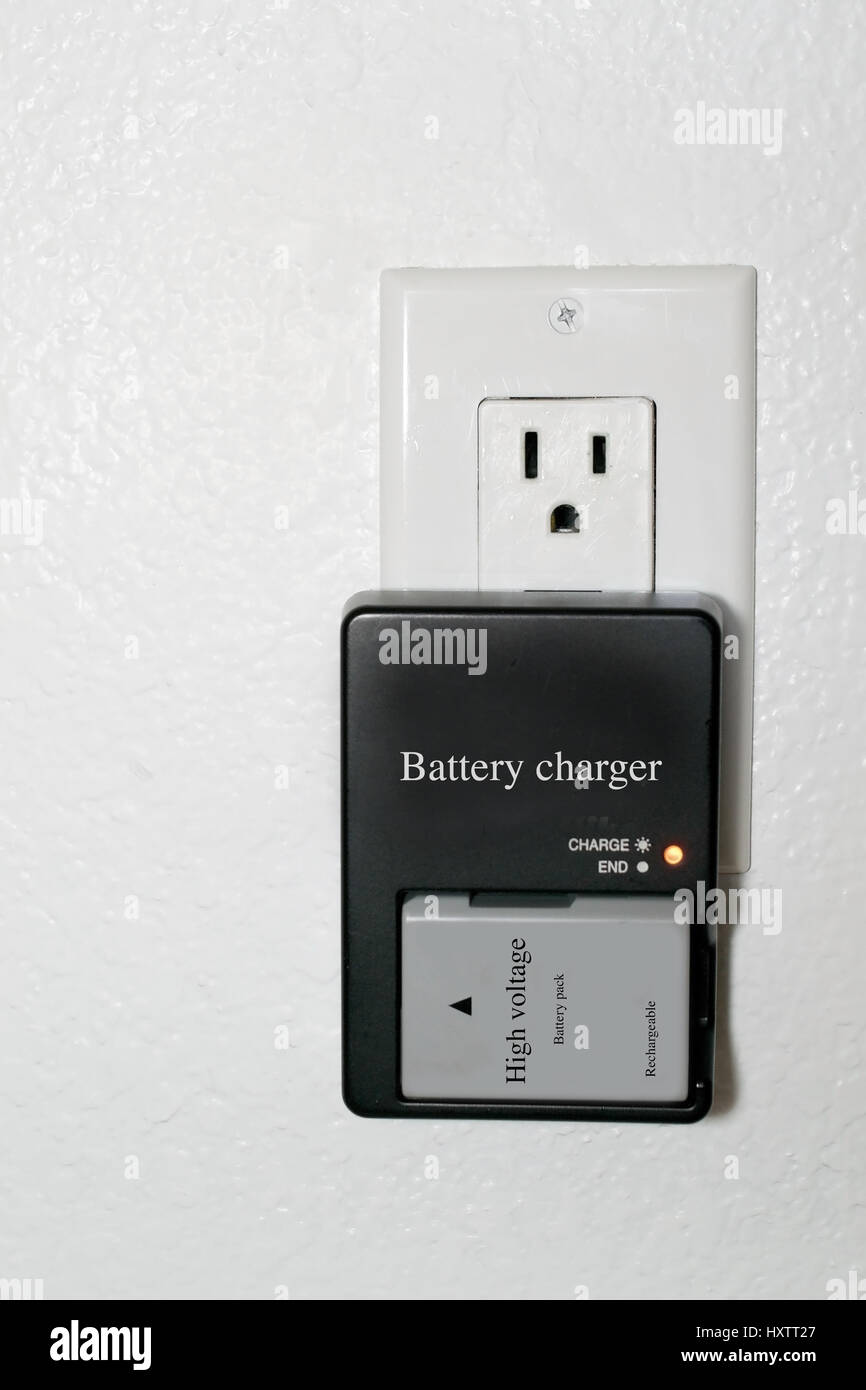 Grey, used, rechargeable lithium battery charging in a black