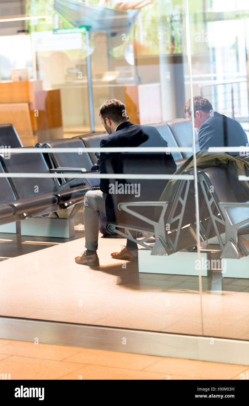 Young male manager with laptop waiting for plane in Hamburg airport lodge Stock Photo