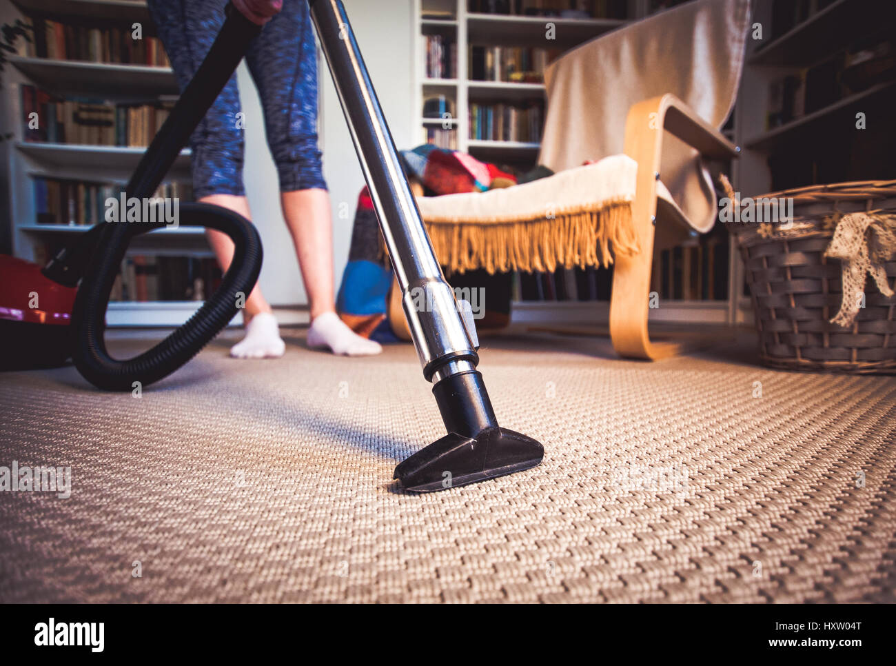 woman cleaning carpet with a vacuum cleaner in room Stock Photo - Alamy