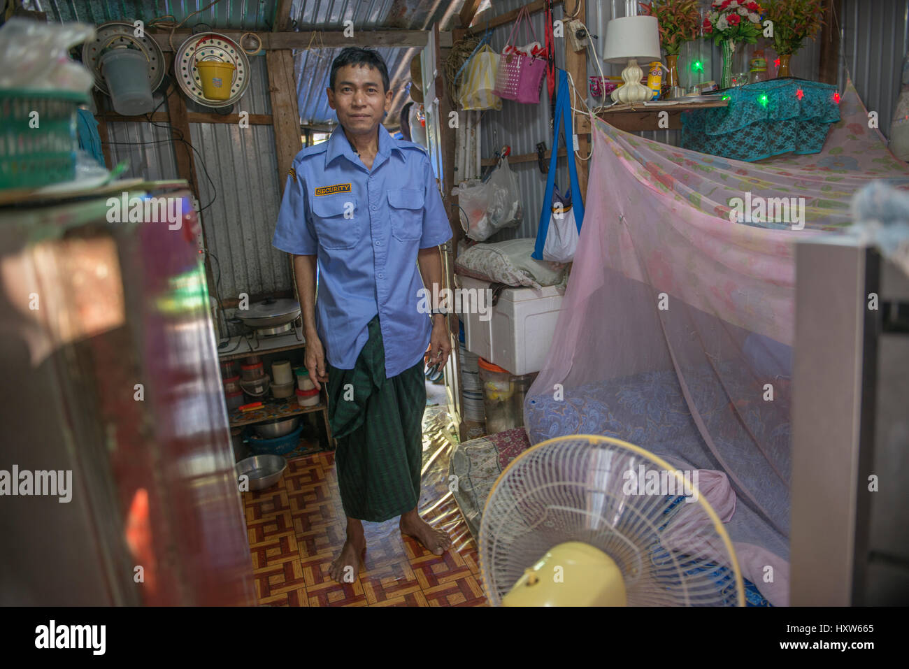 A poor Thai man poses at home in Phuket, Thailand. Nine is a security guard for a luxury property. 09-Mar-2017 Stock Photo