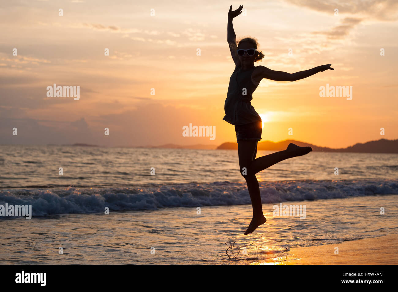 Happy girl jumping on the beach at the sunset time Stock Photo Alamy
