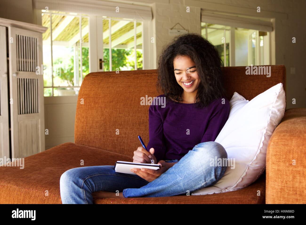 Portrait of a beautiful young woman writing ideas in book Stock Photo