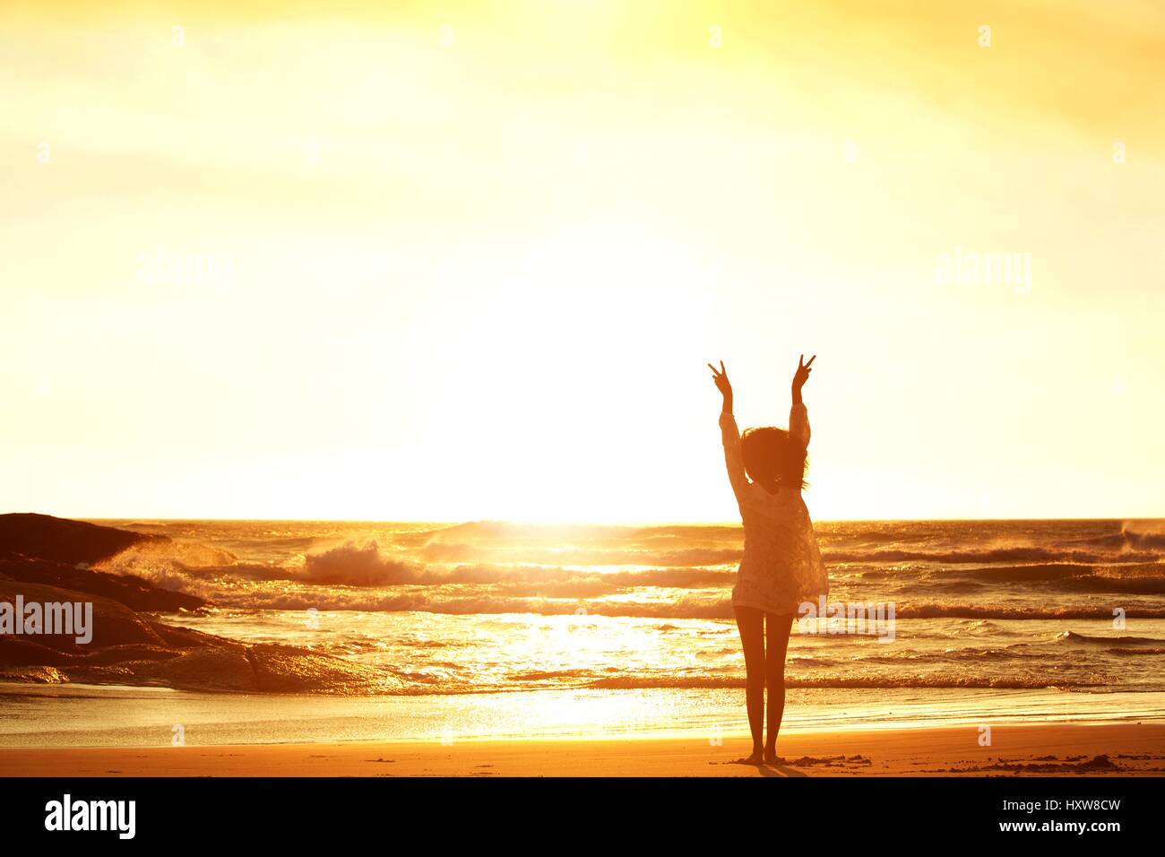 Woman beach raised arms sunset hi-res stock photography and images - Alamy
