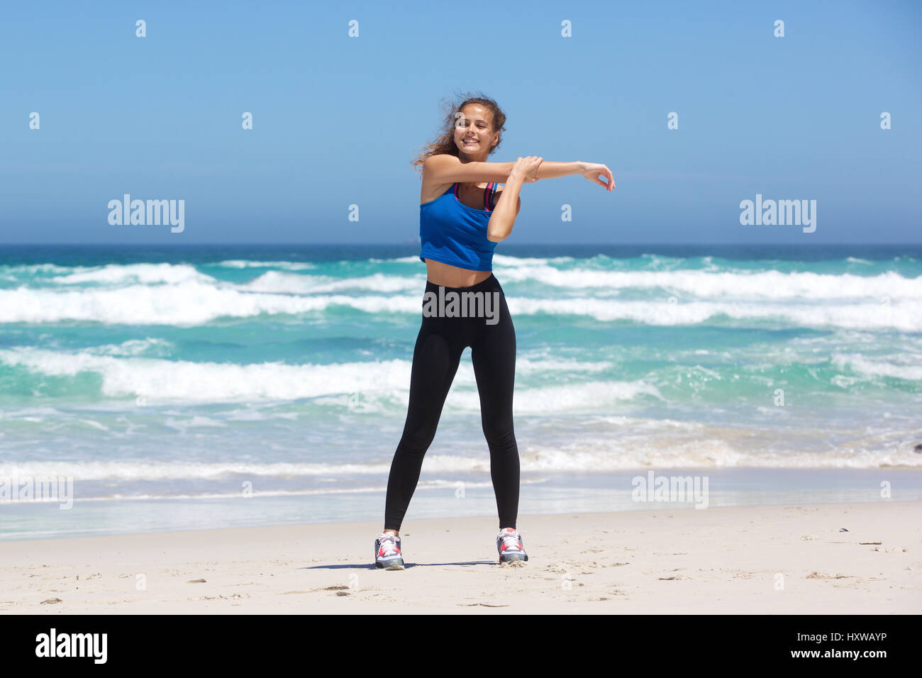 Smiling young woman stretching hi-res stock photography and images - Alamy