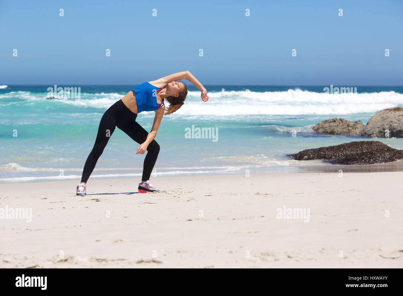 Full body portrait of a fit young woman stretching exercise at the ...
