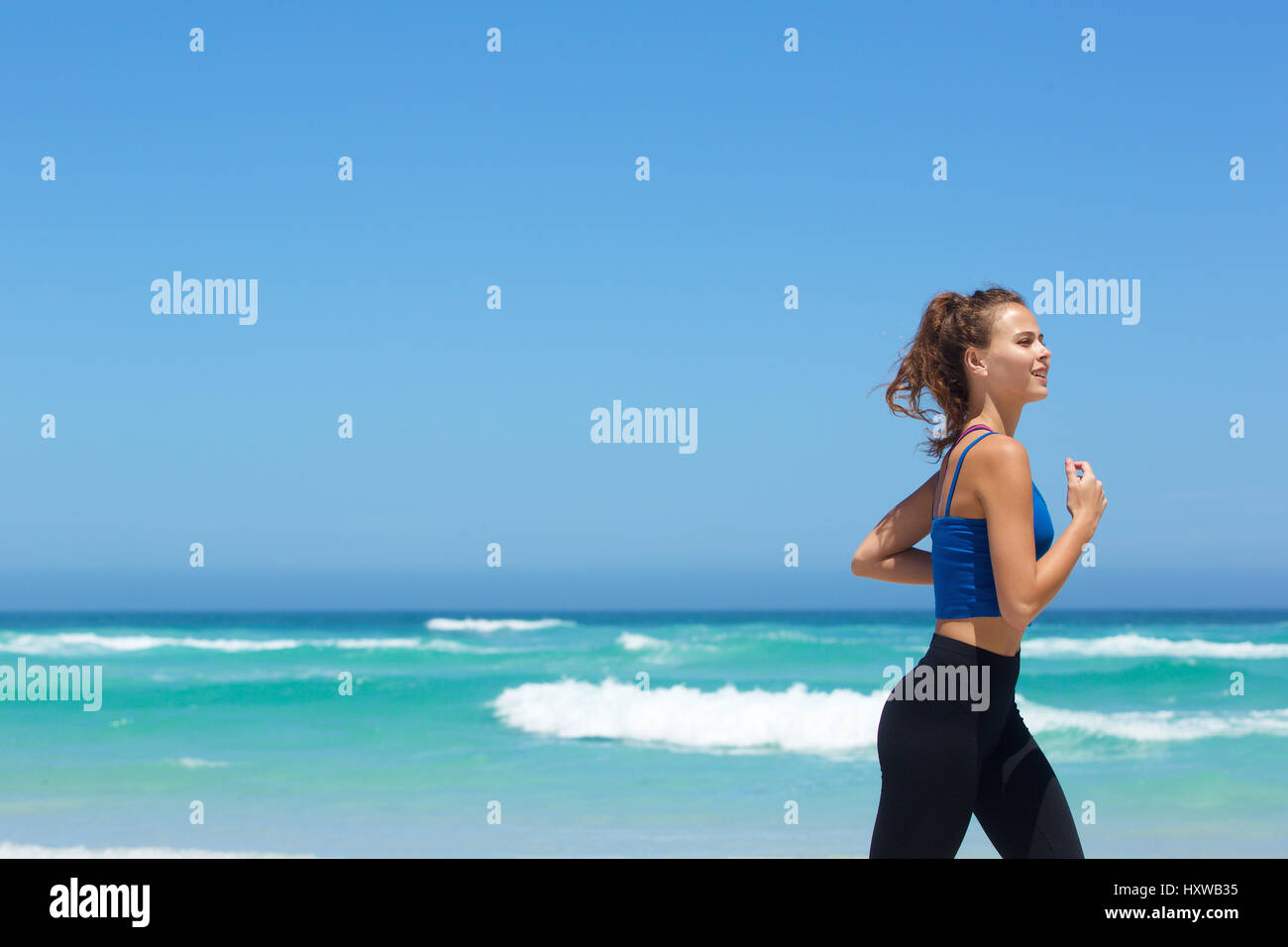 Side portrait of a fit young woman running by the sea Stock Photo - Alamy