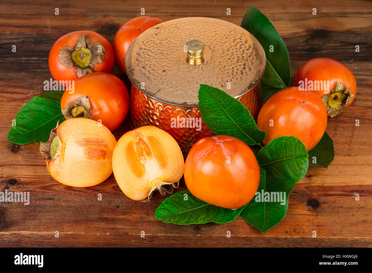 Persimmons kaki fruits composition on old wood. Oriental East still life. Stock Photo