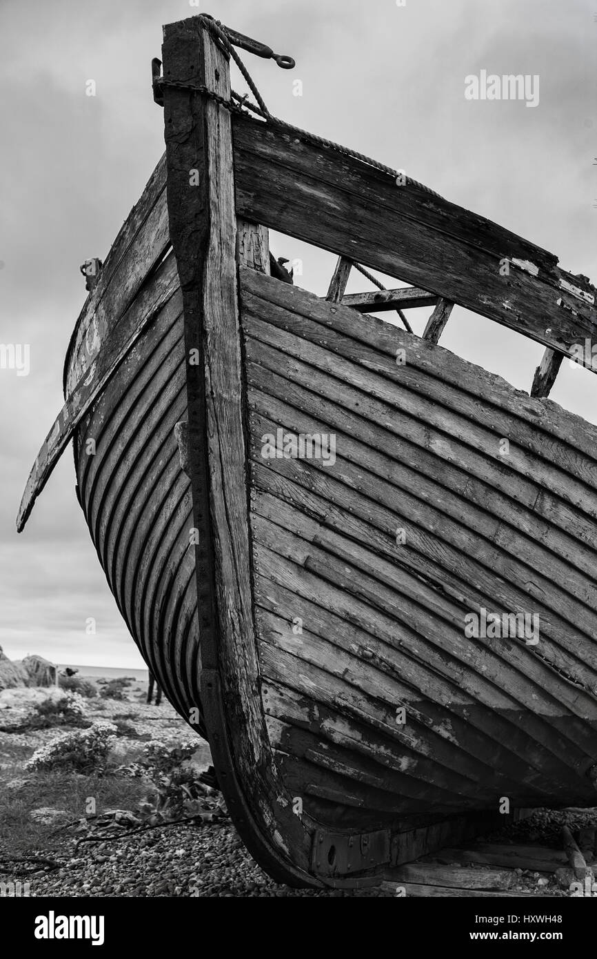 The wreck of an old wooden fishing boat on the shingle beach at ...
