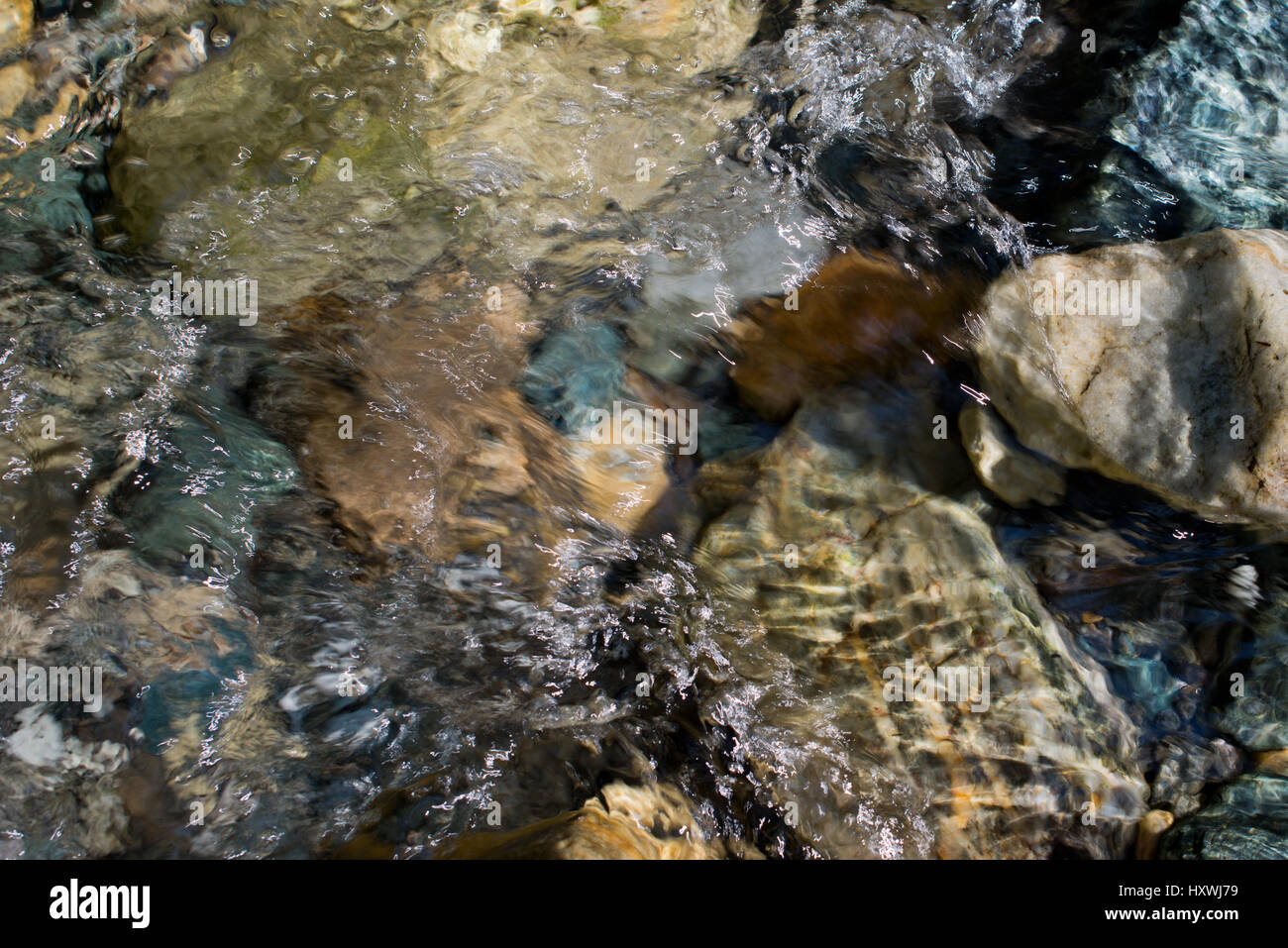 Bergbach Detail, fließendes Wasser über farbigen Steinen in Heiligenblut, Kärnten, Österreich Stock Photo