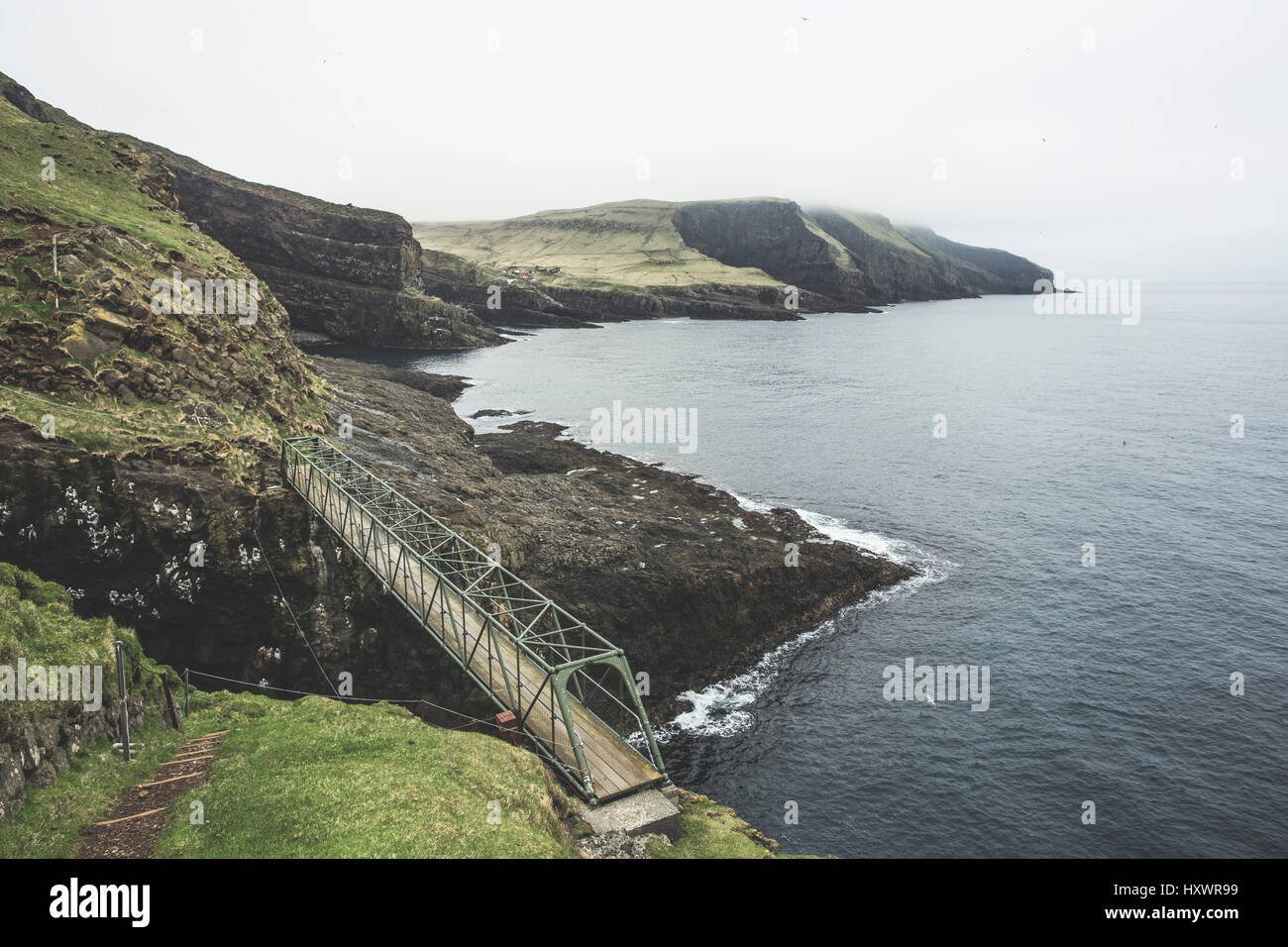 A bridge is connecting the cliffs on Mykines, Faroe Islands. Mykines is