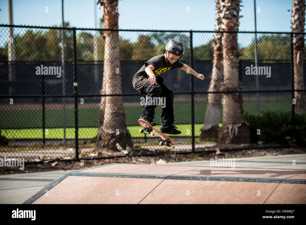 young boy skate boarding with helmet on Stock Photo