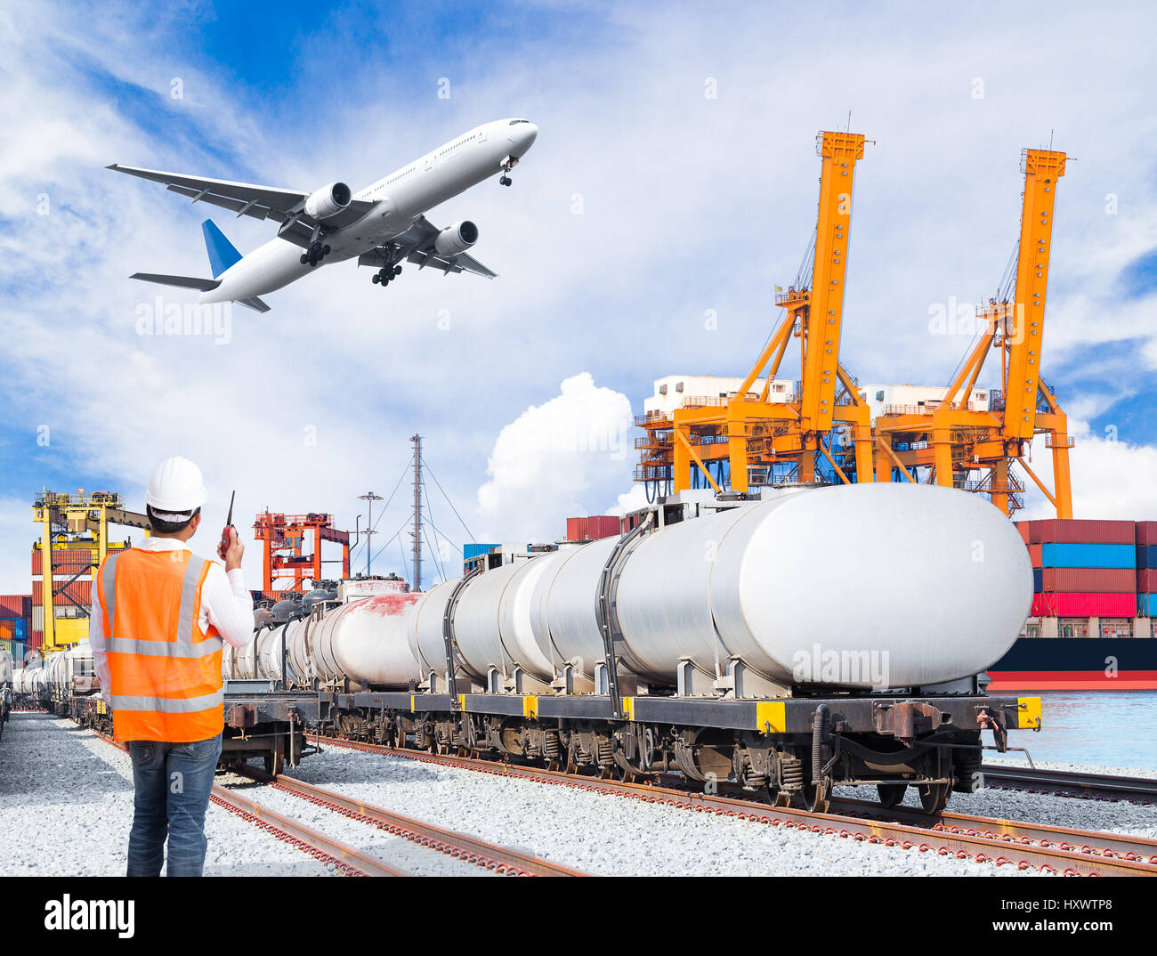 Dock worker talking with radio communication against freight train for fuel transport and cargo plane infront of the harbor, logistic import export co Stock Photo