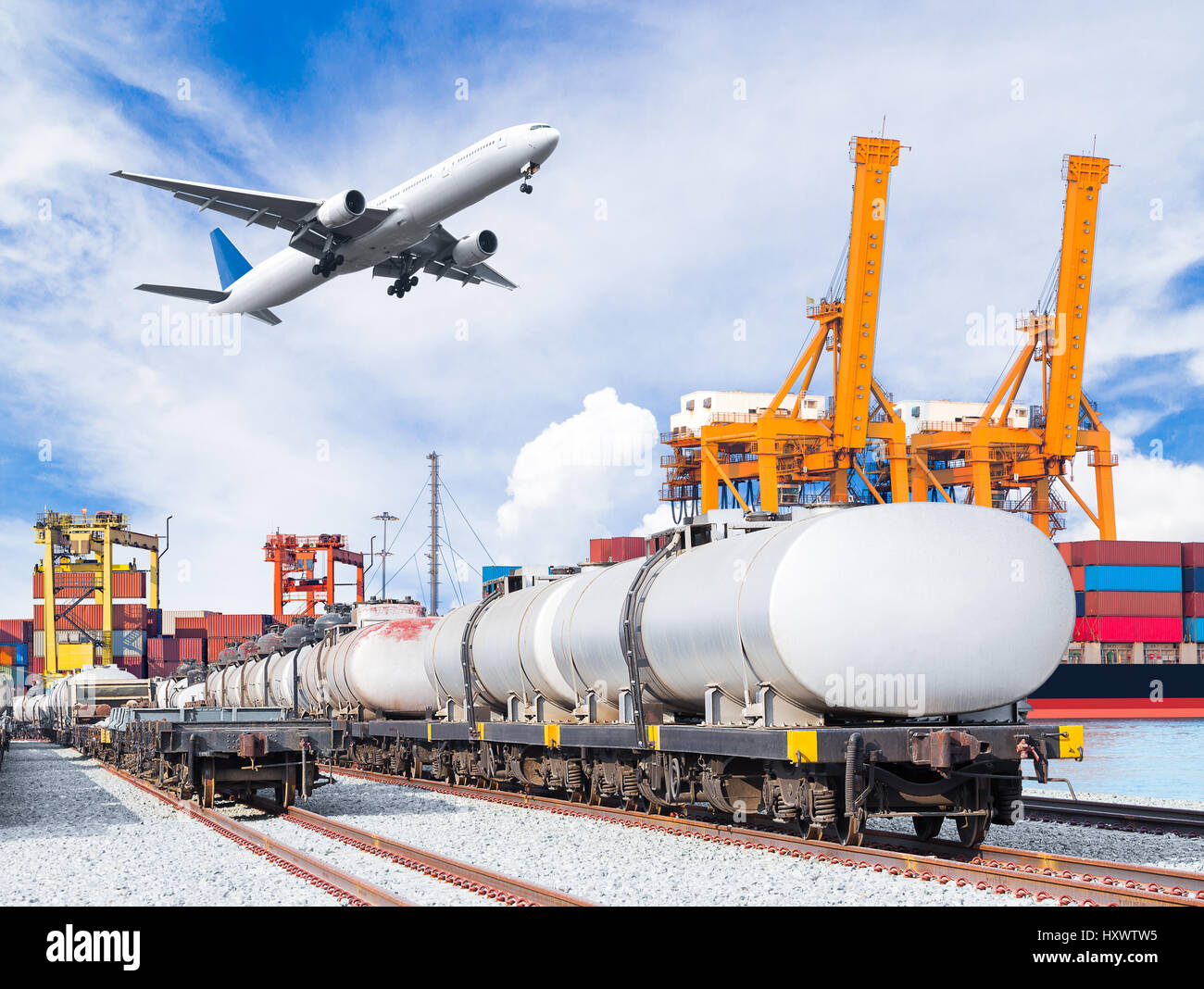 Freight train for oil and fuel transport and cargo plane and container cargo freight ship with working crane loading bridge in shipyard for logistic i Stock Photo